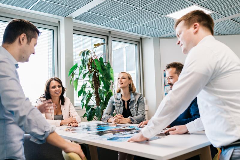 5 people are leading a discussion around table