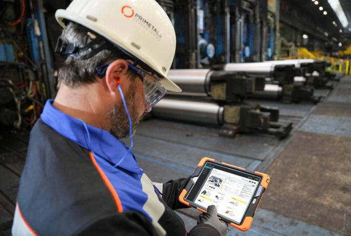 Operator with the Asset Life Expert, ALEX, displayed on a tablet in a steel plant. 