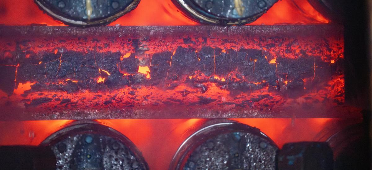 Hot steel slab passing through water‑cooled caster rolls in the soft‑reduction zone during continuous casting