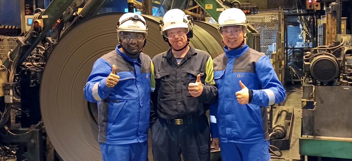 Premsingh Bist, Project Manager & Lead Engineer at Primetals Technologies, Jari Puurtinen, Development Manager for Process Automation & Project Manager for electrics and automation at SSAB Hämeenlinna, and Dong Yan, Drives Commissioning Engineer at Primetals Technologies, on site when the first coil was produced after the completion of Phase 1 of the millstand modernization at SSAB Hämeenlinna.