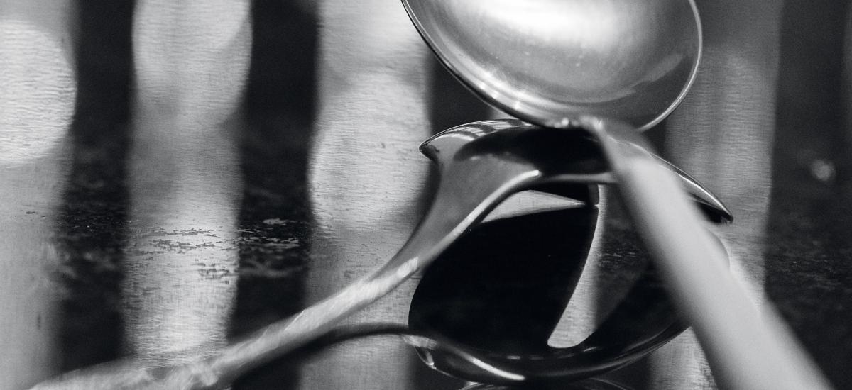 Two spoons against a blurry, elegant background.