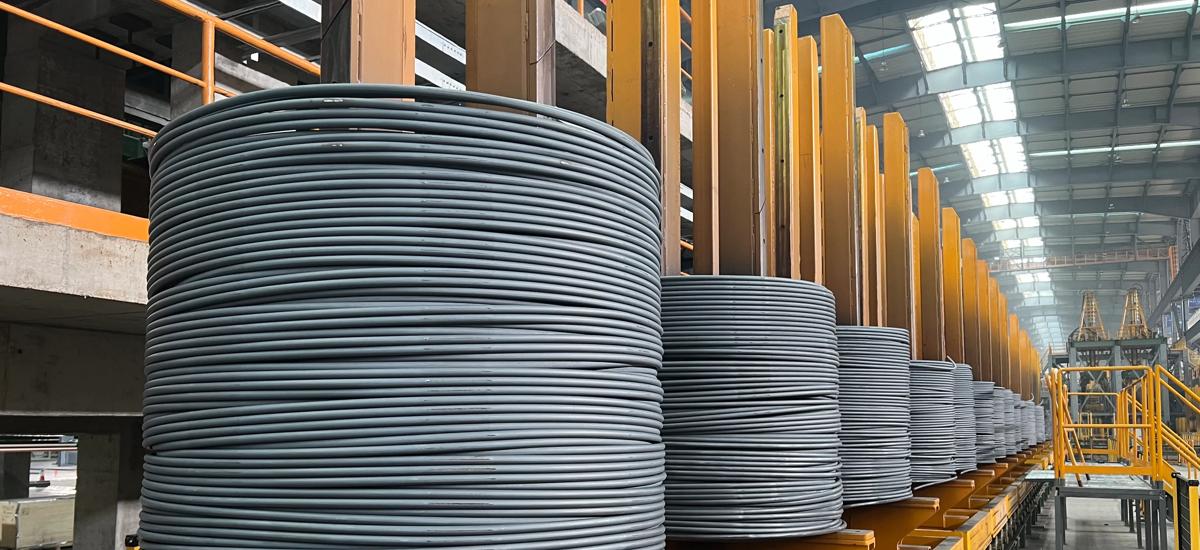 Coiled stainless steel bar on compactors waiting to be tied