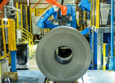 A precisely wound coil at the exit of a cold rolling mill, with evenly layered steel strip demonstrating excellent tension control and high surface quality.