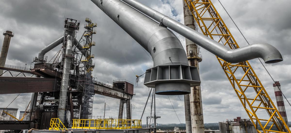 Construction of the gas cleaning plant from Primetals Technologies – a 1000-ton crane lifting the final piece of the downcomer into position.