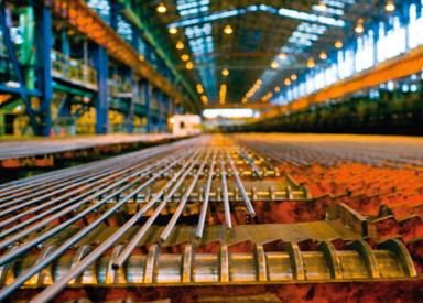 Rebar moving across the cooling bed inside a high‑speed rebar mill