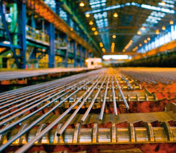 Rebar moving across the cooling bed inside a high‑speed rebar mill