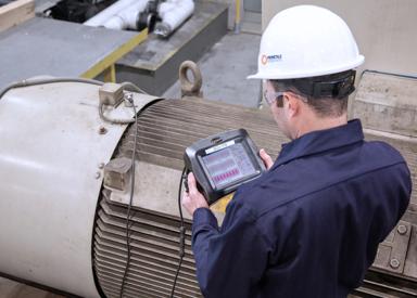Technician performing route-based vibration analysis as part of predictive maintenance to assess steel plant equipment health.