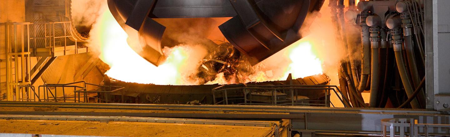 Picture of a scrap bucket charging scrap to the electric arc furnace