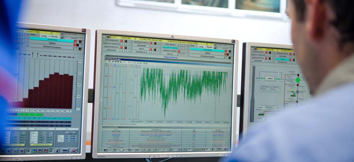 A service engineer sits in front of a service screen, evaluating data to assess maintenance needs and identify optimization opportunities for the steel plant or rolling mill.