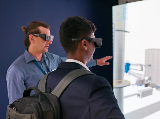 People infront of a LED wall using 3D goggles to experience Primetals Technologies fully interactive hot rolling mill in augmented reality