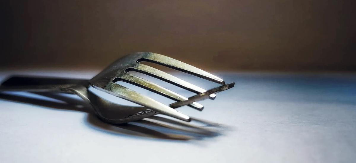 Two forks on a tablecloth.