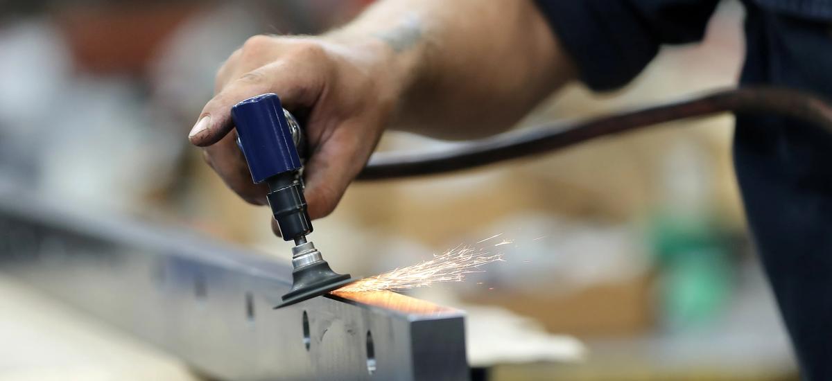 Photo of a service technician grinding a part in the Cortland, Ohio Workshop
