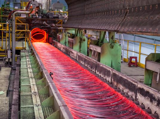 Hot wire rod coil exiting Morgan High-Speed Laying Head and cooling as it moves down the Morgan Stelmor Cooling Conveyor