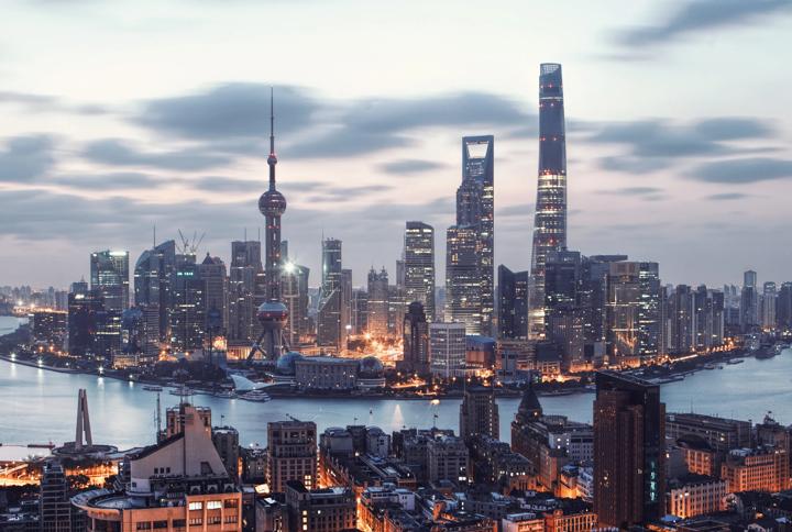 Shanghai skyline at dusk with illuminated skyscrapers and the Huangpu River waterfront
