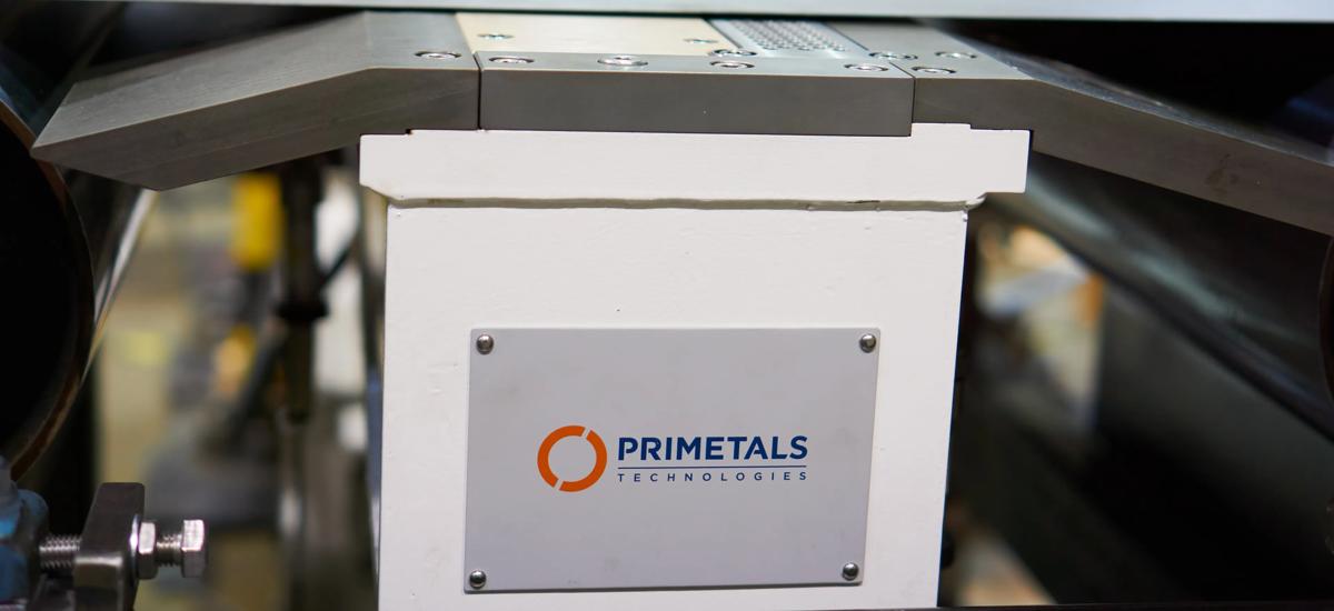 Contactless shape monitor measurement device positioned over a moving metal strip, accurately measuring and analyzing strip shape and flatness in real time without physical contact, ensuring precise quality control during production.