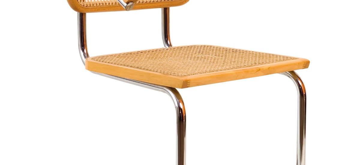 Marcel Breuer’s Cesca Chair (1928) combines chrome-plated tubular steel with woven wicker, an iconic part of his furniture designs. Other versions are also without arms and appear similar to the cantilever chair by Mies van der Rohe.