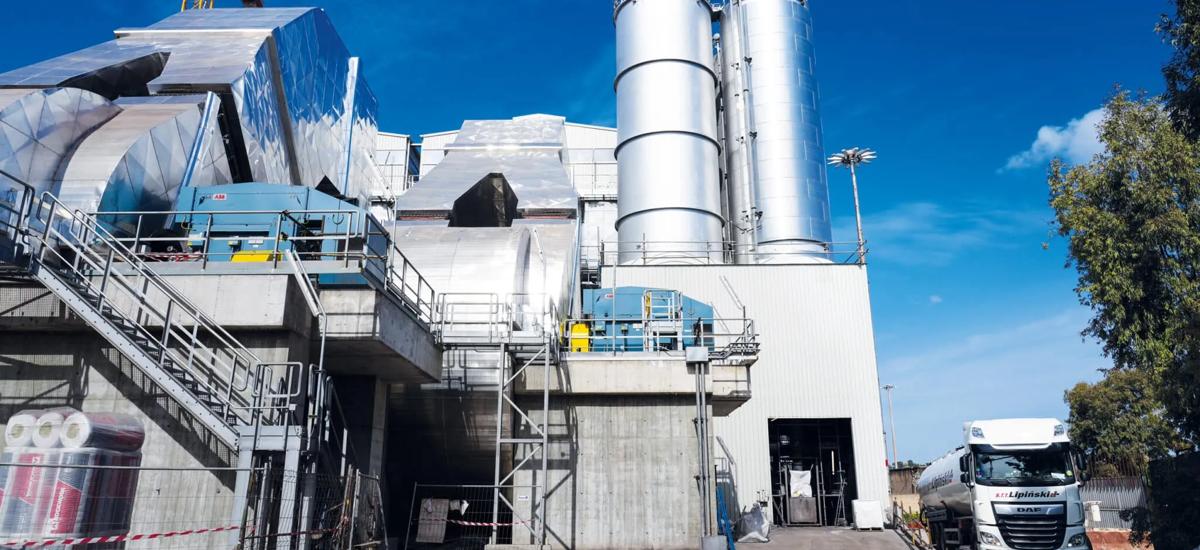 The side view of the first two MEROS units unveils large induced-draft fans (left) and silo batteries for additives and extracted substances (right).