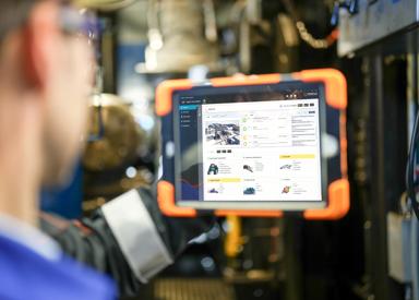 Operator with the Asset Life Expert, ALEX, displayed on a tablet in a steel plant. 