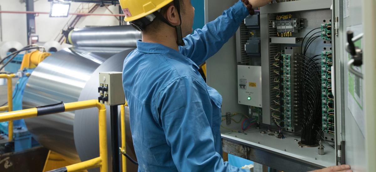 mill operator looking in the Air Bearing ShapeMeter transducer cabinet in a mill