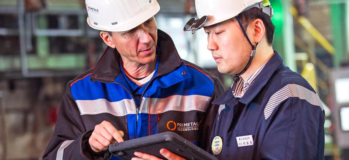 Two engineers talking one having a tablet  in his hands